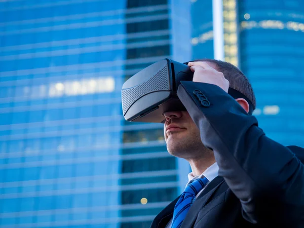 Businessman using virtual reality glasses in a business center a
