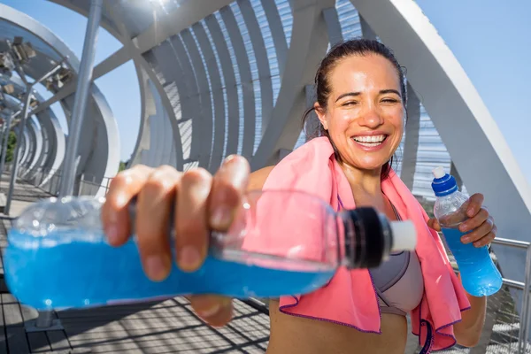 Happy female runner with energetic drinks for hydration