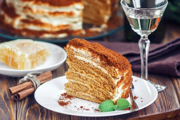 Slice of homemade layered honey cake with honeycomb, mint and cinnamon, traditional food of Jewish New Near. Sweet food