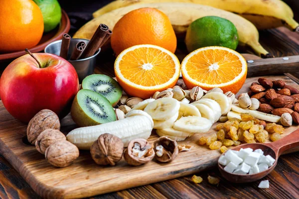 Fresh fruits. Healthy food. Mixed fruits and nuts background.Healthy eating, dieting, love fruits. Studio photography of different fruits and nuts on old wooden table. Organic Healthy Assorted Fruits.