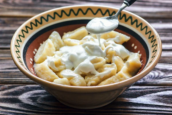 Ukrainian traditional lazy dumplings with cottage cheese. Ukrainian Cuisine. Homemade vareniki in a bowl, delicious lunch. Healthy breakfast - health and diet concept on the wooden table, closeup.