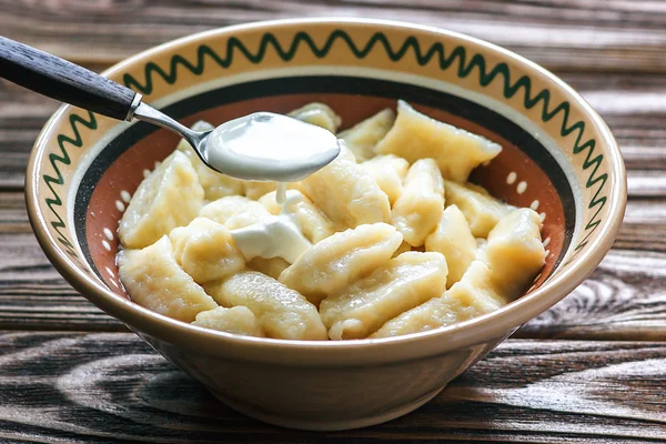 Ukrainian traditional lazy dumplings with cottage cheese. Ukrainian Cuisine. Homemade vareniki in a bowl, delicious lunch. Healthy breakfast - health and diet concept on the wooden table, closeup.