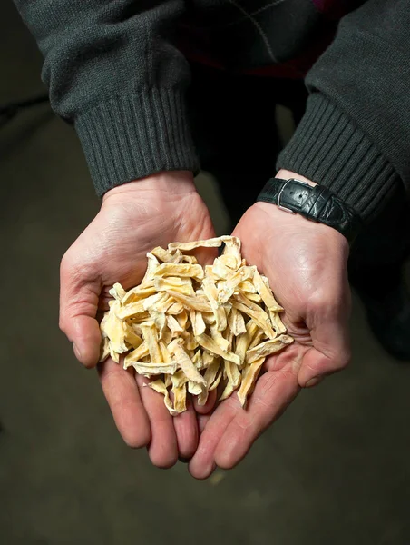 Close-up of Man holding dried fruits at the factory