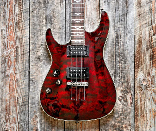 Electric red guitar body on wooden background vintage look