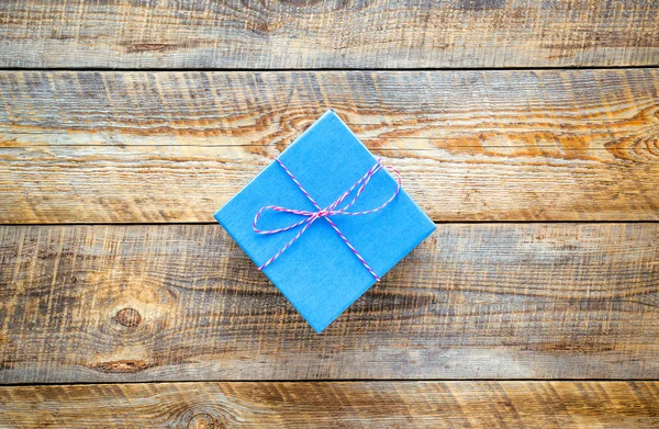 Small blue gift box on empty wooden table