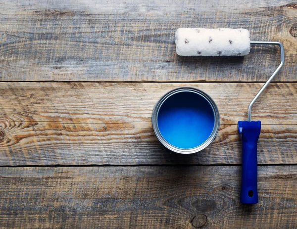 Painting with  can of blue paint and roller top view