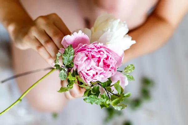 Florist making a bouguet of white flowers and peonies