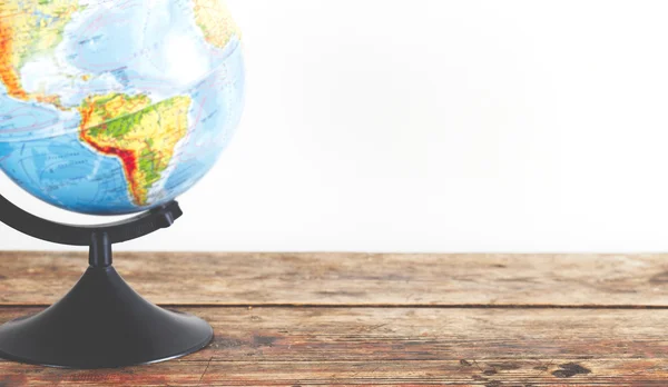 Globe standing on empty wooden table