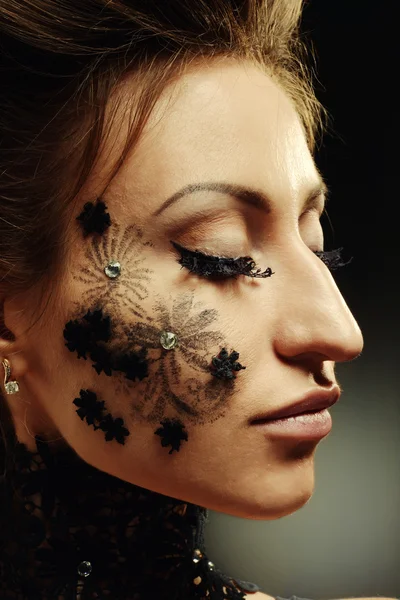 Woman black lace flowers on face