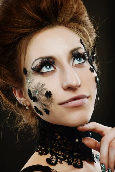 Woman black lace flowers on face