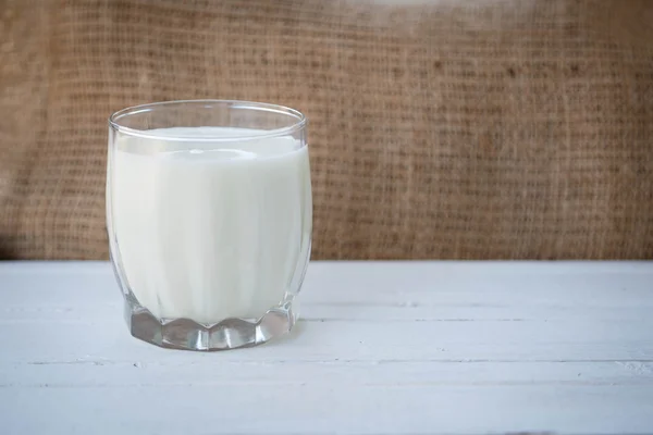 Healthy lifestyle. Healthy food. Proper nutrition. Useful vitamins food. Yogurt diet. A transparent cup of yogurt on a wooden table on a light brown background.