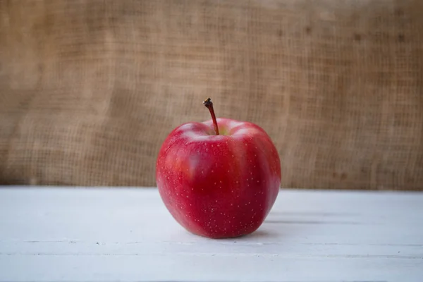 Healthy lifestyle. Proper nutrition. Fruit plate. Useful vitamins food. Apple yogurt diet. Red ripe apples and a cup of yogurt on a wooden table on a light brown background