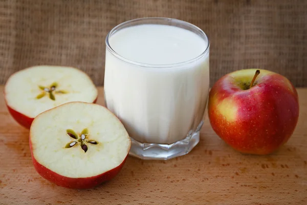 Healthy lifestyle.  Useful vitamins food. Proper nutrition. Fruit plate. Apple yogurt diet. Red ripe apples and a cup of yogurt on a wooden table on a light brown background