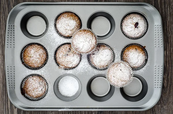 Top view of muffins sprinkled with powdered sugar in baking dish