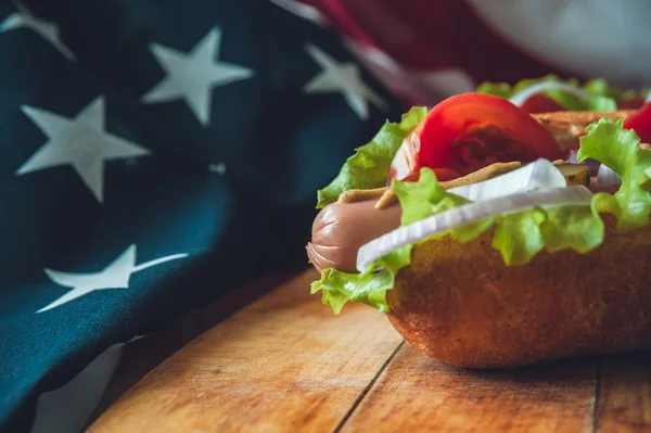 Two fresh hot dogs on a wooden Board, glasses with Cola and American flag