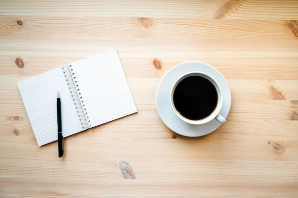 Coffee mug and a blank Notepad