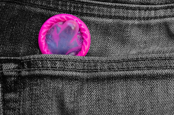 Pink condom pack in back pocket jeans,abortion concept.