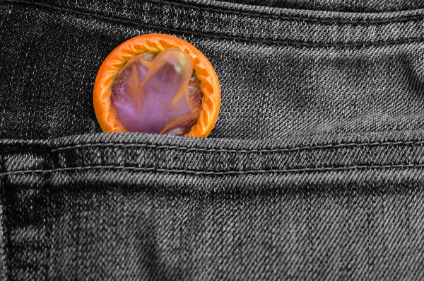Yellow condom pack in back pocket jeans,abortion concept.