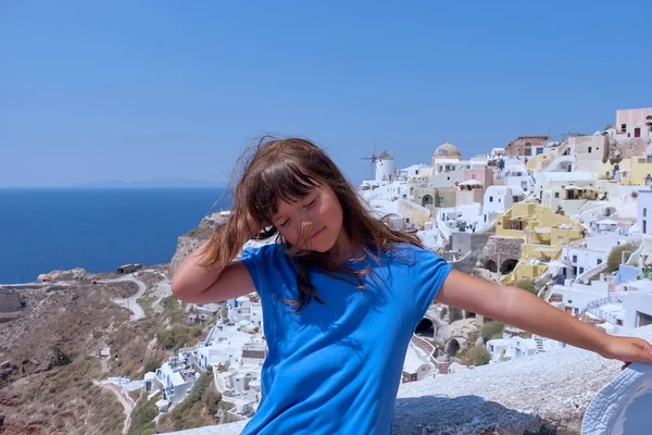 Girl dressed in blue dress and hat in the Greek island Santorini