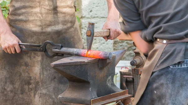 Demonstration by two blacksmiths labor metal to the old way