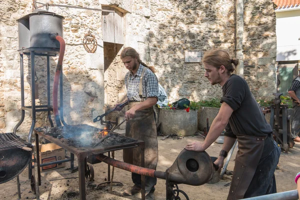 Demonstration by two blacksmiths labor metal to the old way