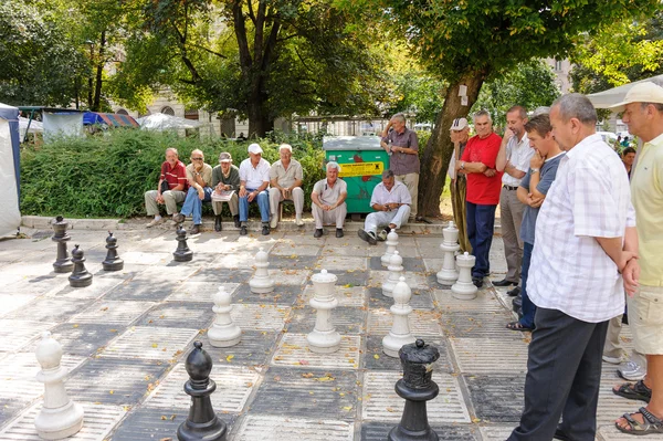 Men at outdoor giant chess game