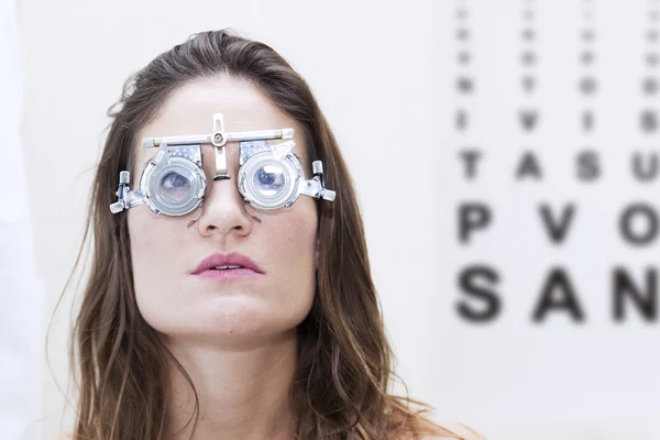 Beautiful woman test new auxiliary lenses with phoropter