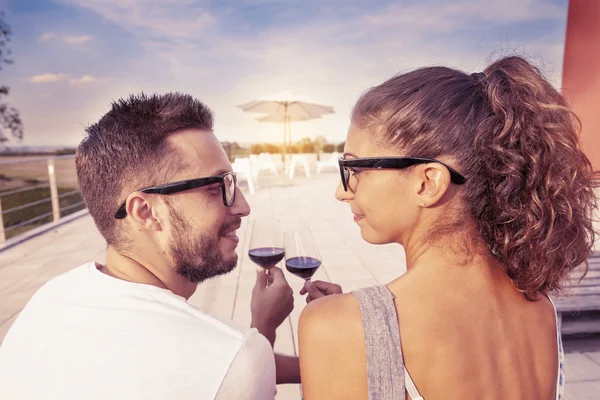 Young couple toast on a terrace at sunset