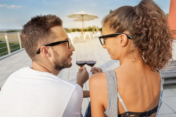 Young couple toast on a terrace at sunset