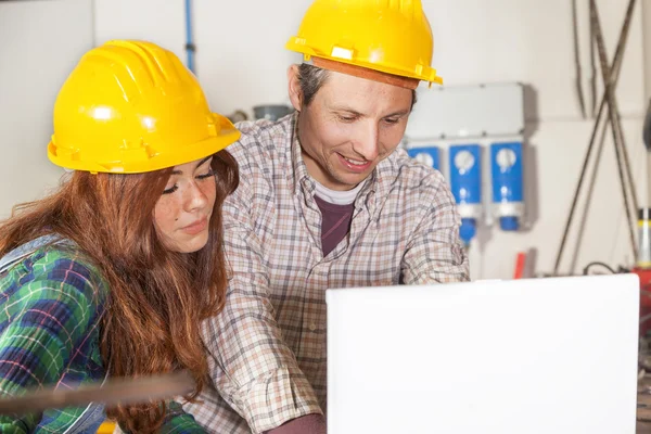 Couple of engineers consult the computer in a steel mill