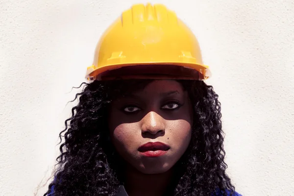 Portrait of young african american female worker with yellow hel