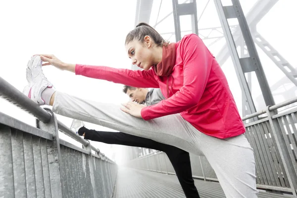 Young runner stretch muscles before the race