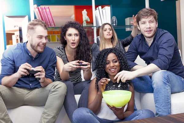 Group of people having fun on the couch playing with the joystic