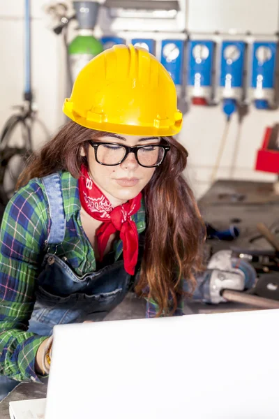 Portrait of pretty engineer consult the computer in a steel mill