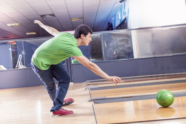 Young boy pulls the ball on the bowling alley