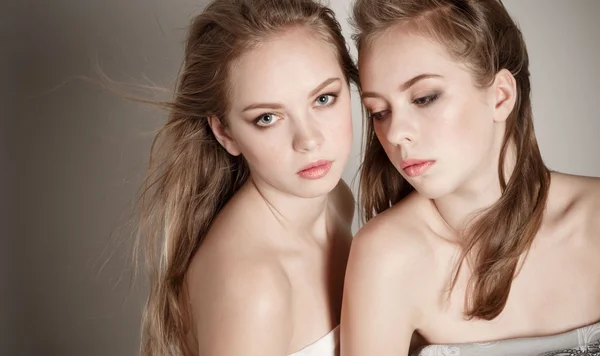 Two young beautiful woman twins blonde