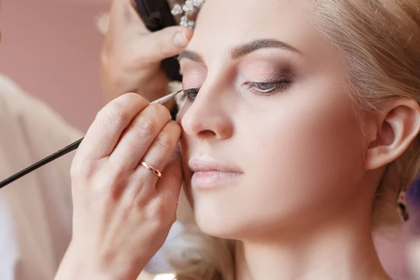 Make-up artist doing makeup for photos