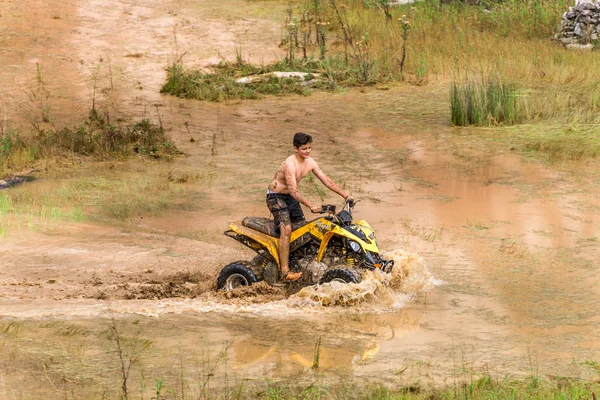 Off road on quad bike rally over mud puddle