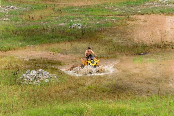 Off road on 4x4 quad bike through mud puddle