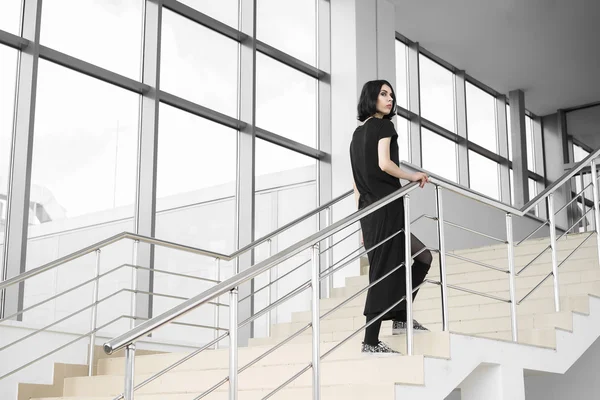 Woman in black walking upstairs