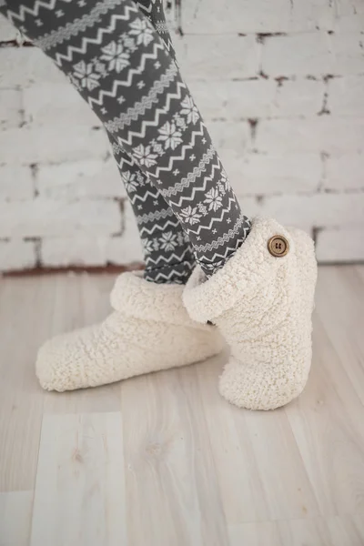 Close-up of woman's legs in printed tights and cozy home socks