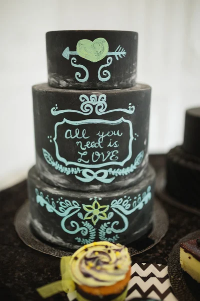 Black decorated wedding cake with text