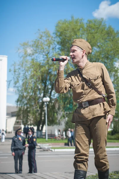 LUBAN, BELARUS - MAY 9, 2015: a man wearing the uniform of a Soviet soldier sings a song on stage