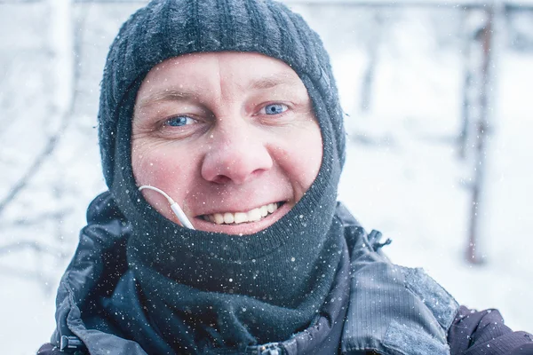 Smiling man shoots selfie in winter outdoors