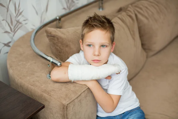 Little boy with a broken arm. child in a cast. funny kid after accident.