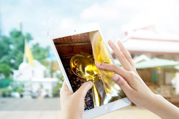 Female hands are pointing on touch screen device with Golden rec