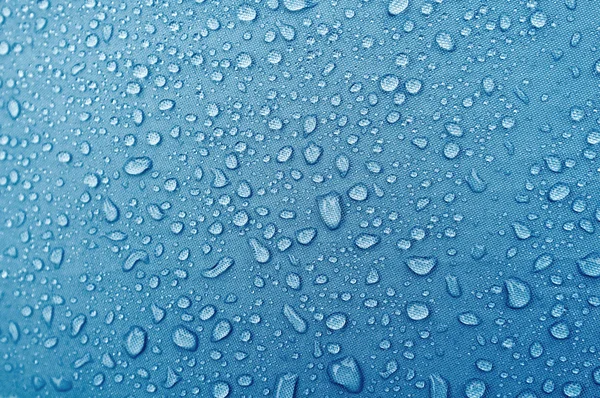 Water droplets on blue fiber waterproof fabric.