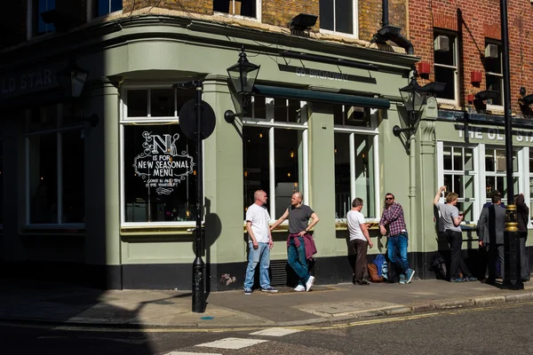 LONDON, UK - APRIL14, 2015: Exterior of pub in  London with lots of people drinking and socialising after work.