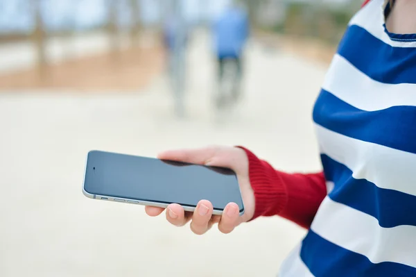 Closeup picture of person using a smart phone on outside background