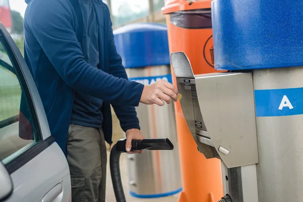 Person using self service automatic car wash vacuum machine.